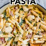 Tuscan chicken pasta recipe in a pot with a spoon.