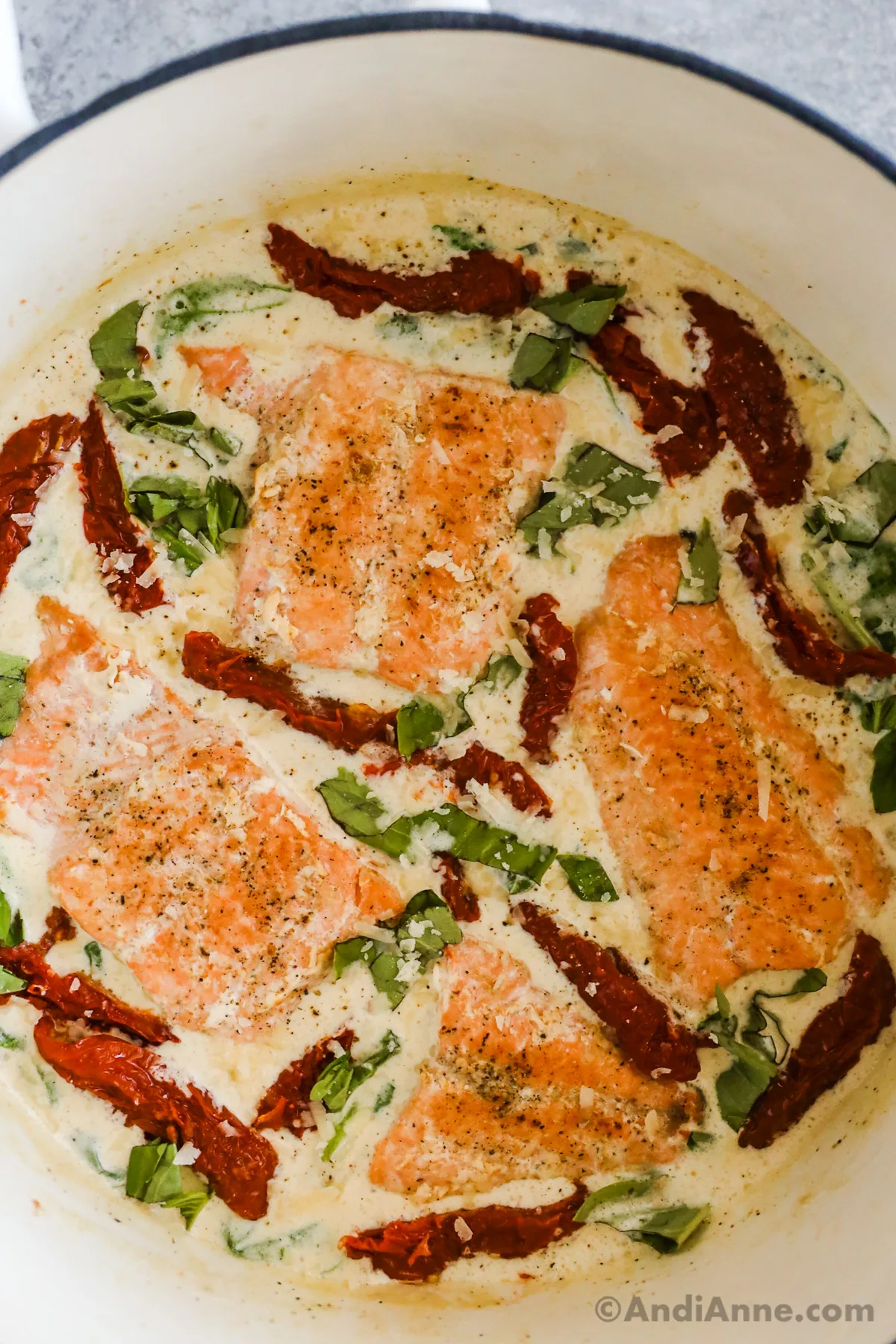 Close up of tuscan salmon recipe with spinach, sun dried tomatoes all in a white sauce.