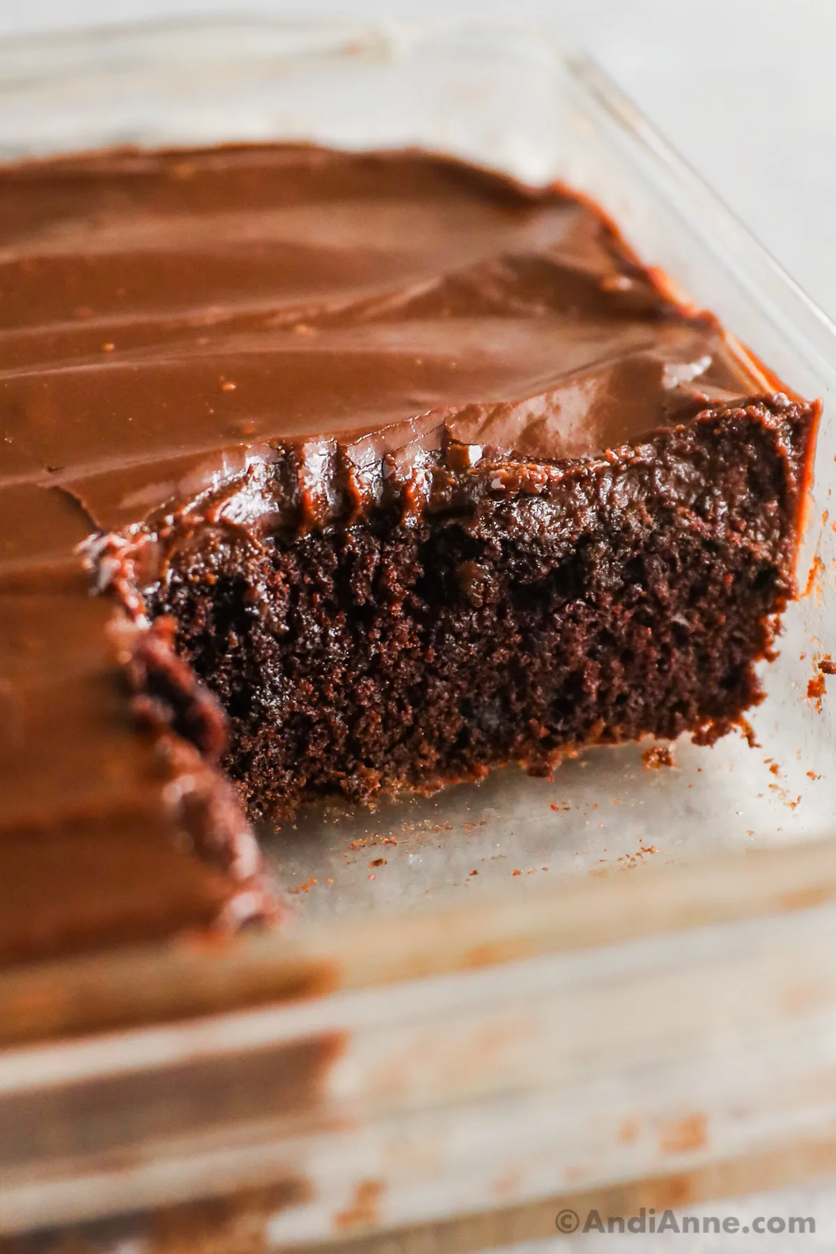 A slice of chocolate cake cut out in a glass baking dish.