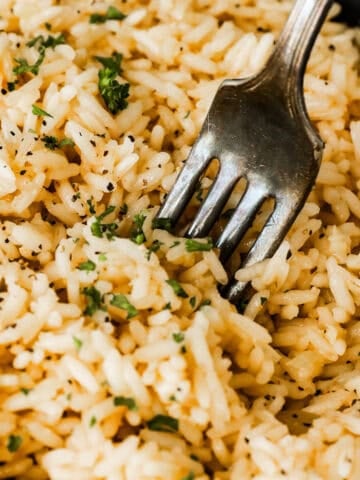 close up of garlic butter rice with a fork
