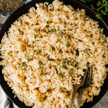 a plate of garlic butter rice with two forks