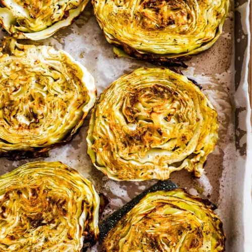 Roasted cabbage steaks on a baking sheet.