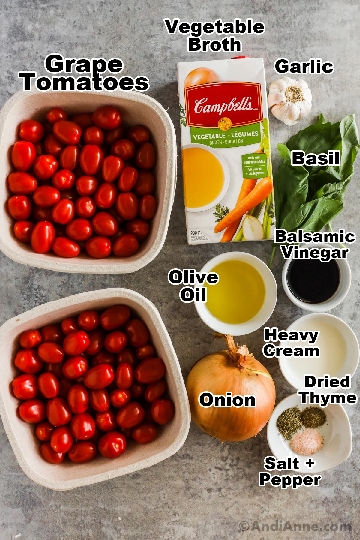 Recipe ingredients including bowls of grape tomatoes, carton of broth, fresh basil, yellow onion, bowls of olive oil, balsamic, cream and spices.