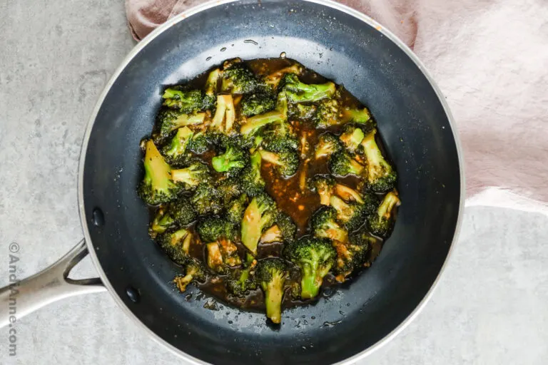 A frying pan with chopped broccoli in a honey garlic sauce.