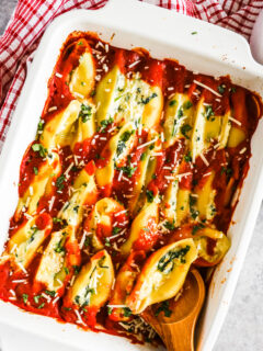 Spinach ricotta stuffed shells in a white baking dish.