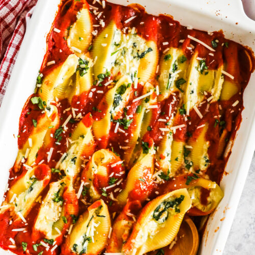 Spinach ricotta stuffed shells in a white baking dish.