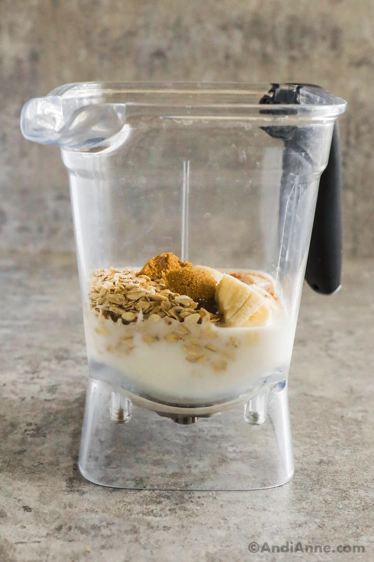A blender with milk, rolled oats, sugar, cinnamon, and banana.