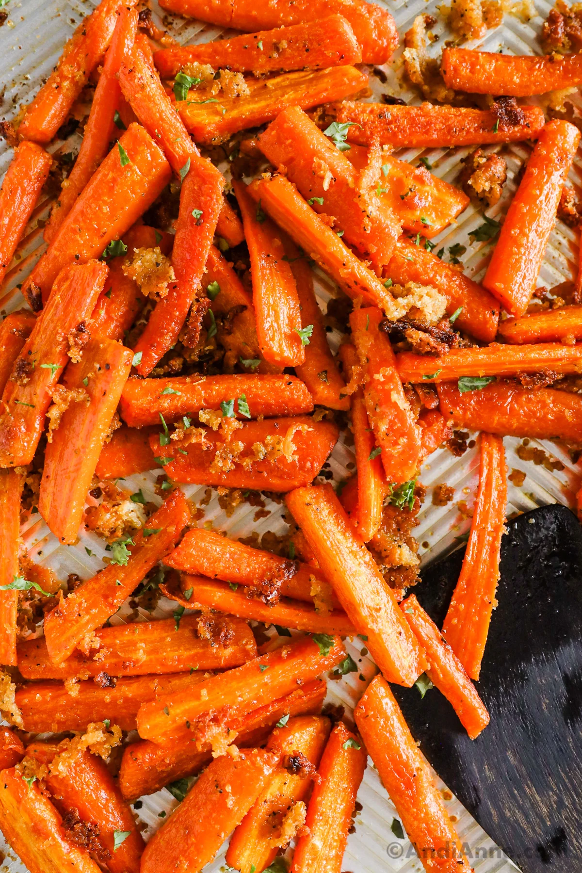 Close up of roasted garlic parmesan carrots on a baking sheet.