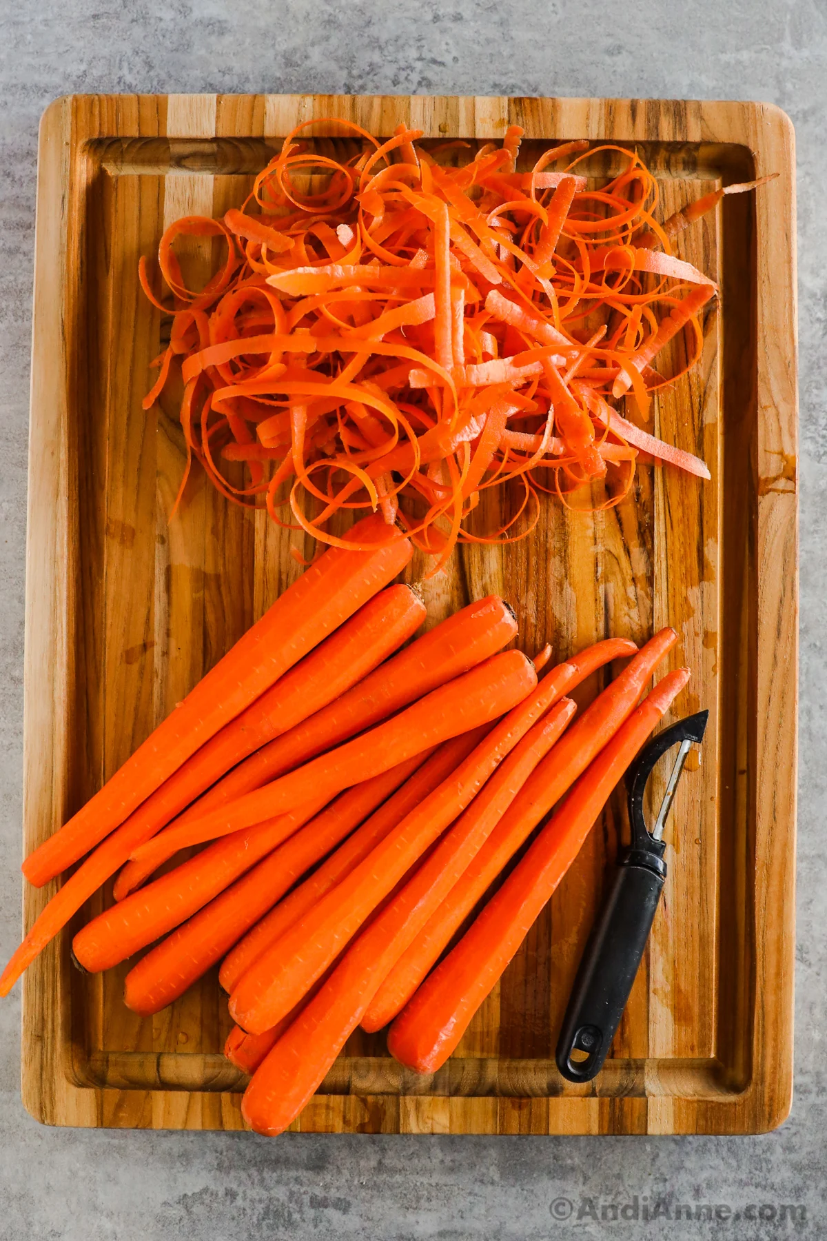 A stack of peeled carrots on a cutting board.