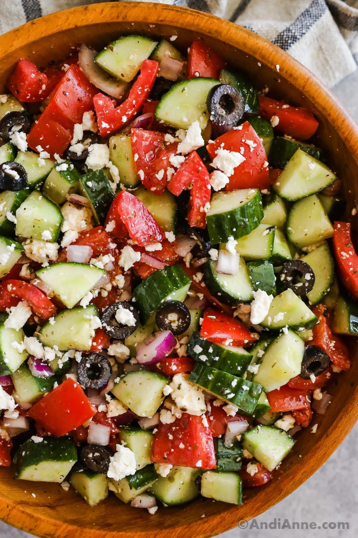 Close up of greek cucumber salad with tomatoes, olives, onion and feta cheese.