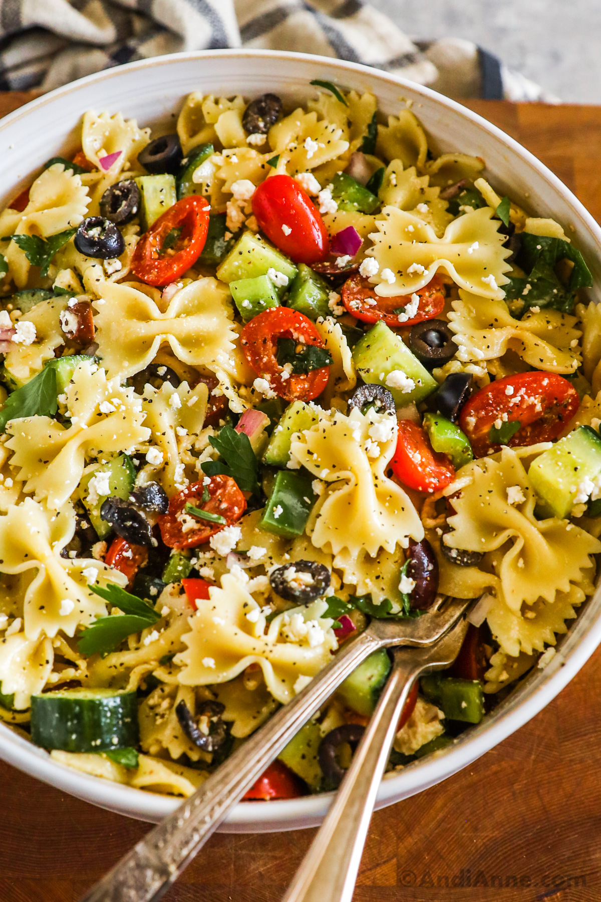 Greek pasta salad recipe with farfalle pasta, tomatoes, olives, bell pepper and feta cheese.