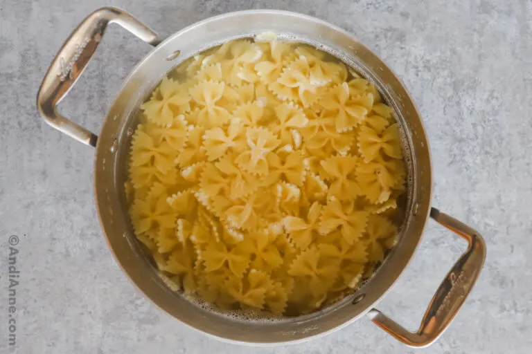 A pot of farfalle pasta salad in water.