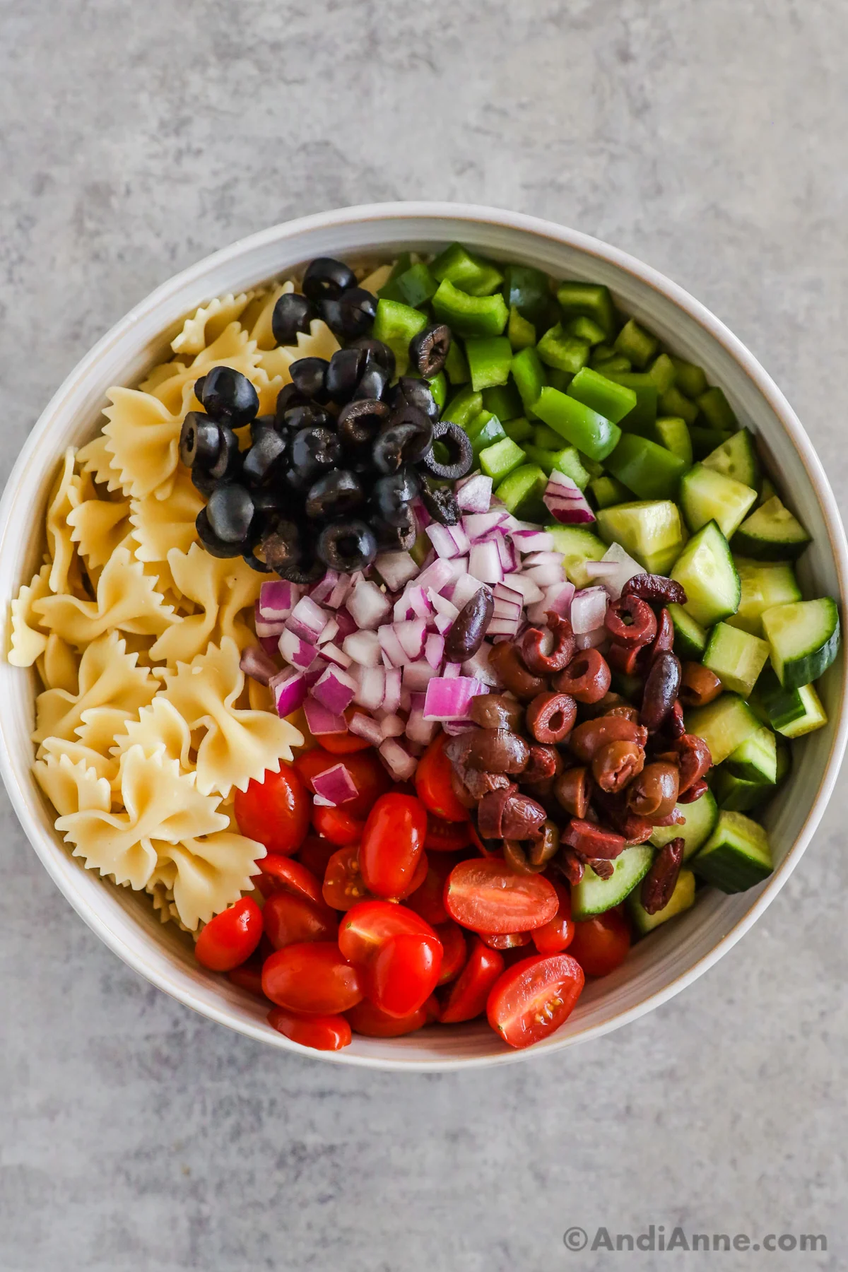 Various vegetables and pasta noodles all in a large bowl.