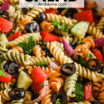 Close up of Italian pasta salad recipe with rotini pasta, tomatoes, cucumber and olives.