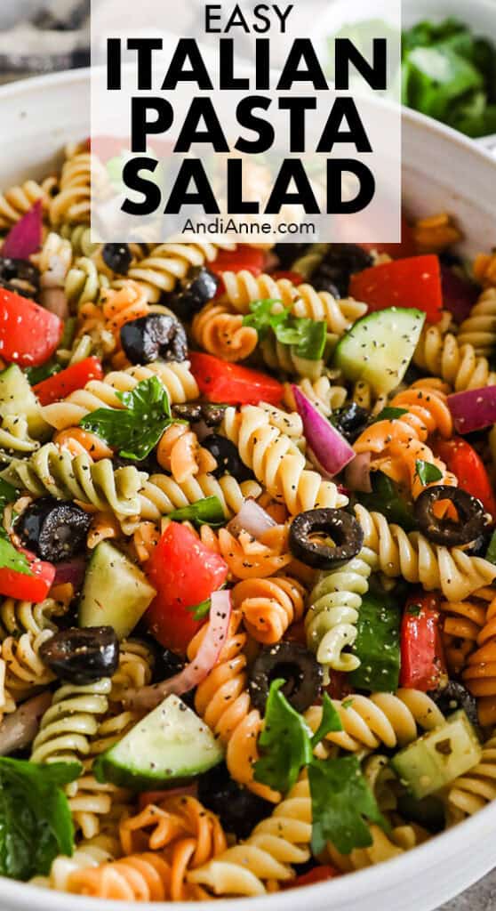 Close up of Italian pasta salad recipe with rotini pasta, tomatoes, cucumber and olives.