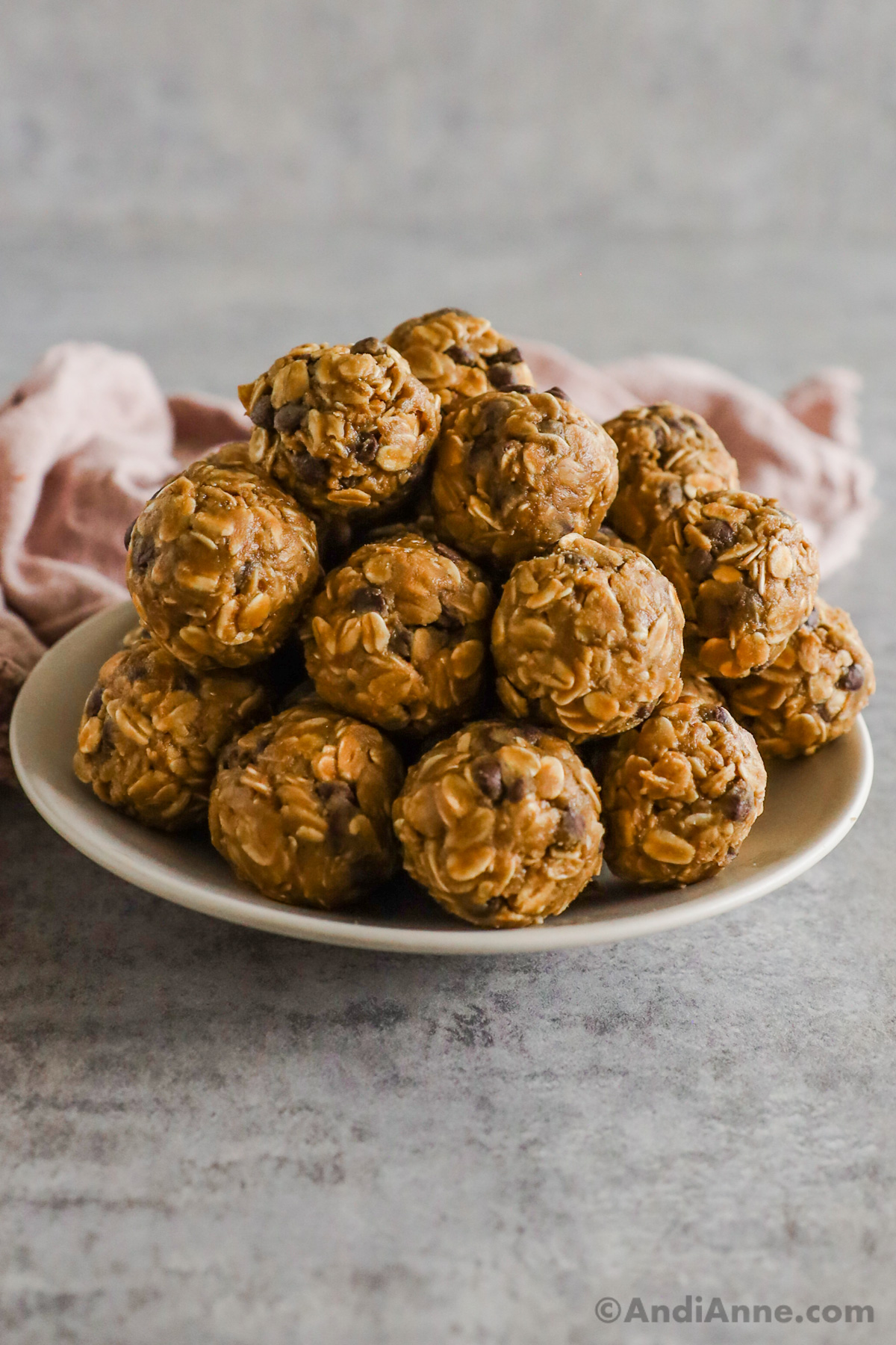 A pile of chocolate chip peanut butter oat balls on a plate.