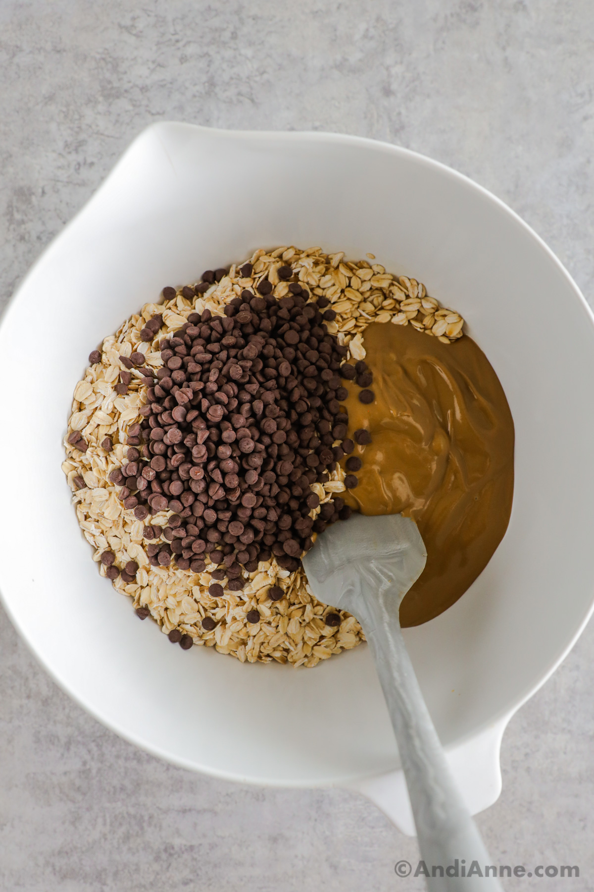 A bowl with rolled oats, peanut butter and chocolate chips inside.