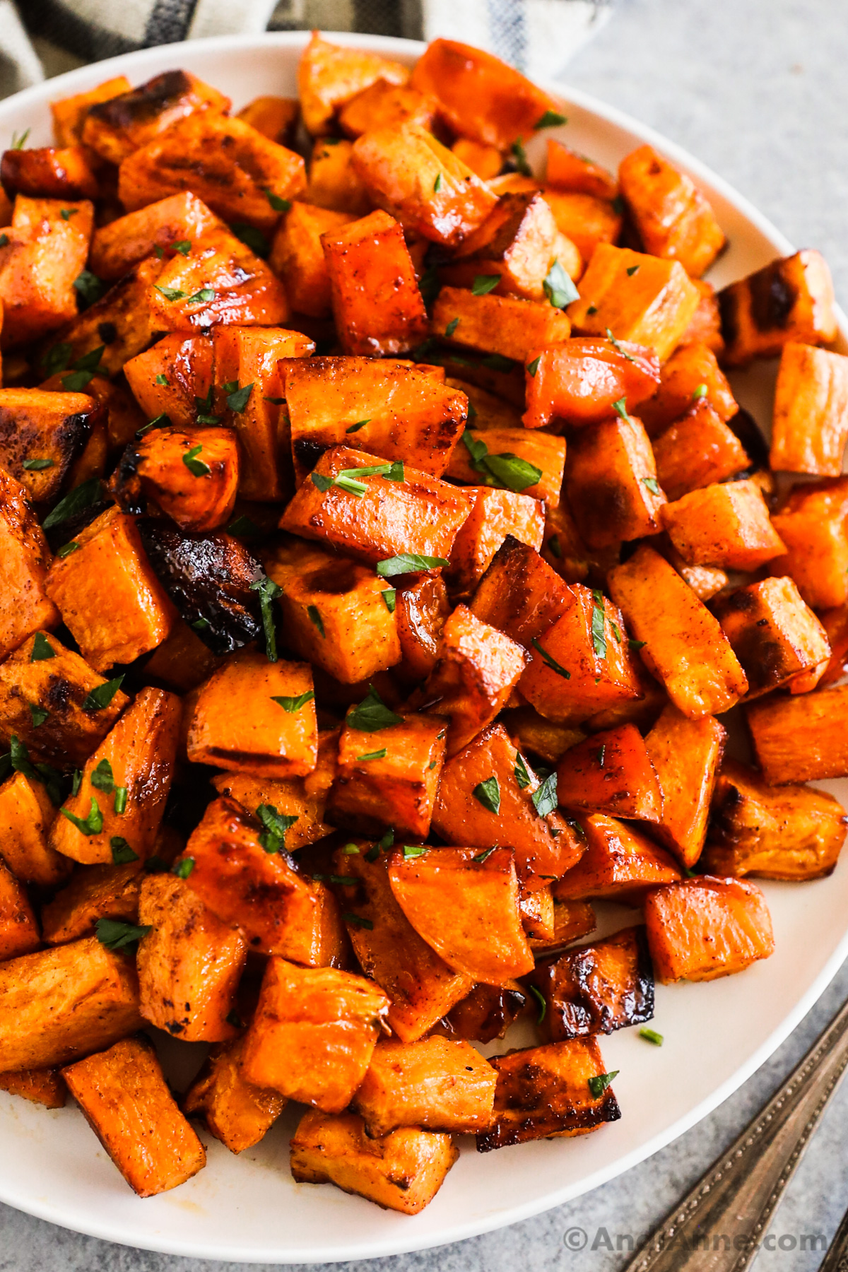 Close up of honey cinnamon roasted sweet potatoes on a plate.