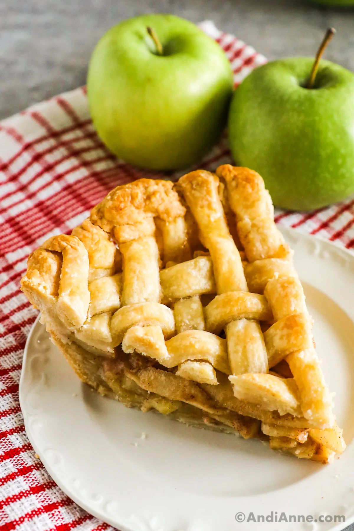 A slice of apple pie with lattice pie crust.