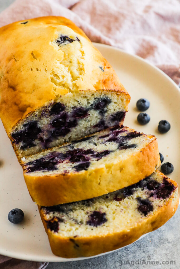 Baked blueberry loaf sliced and on a plate.