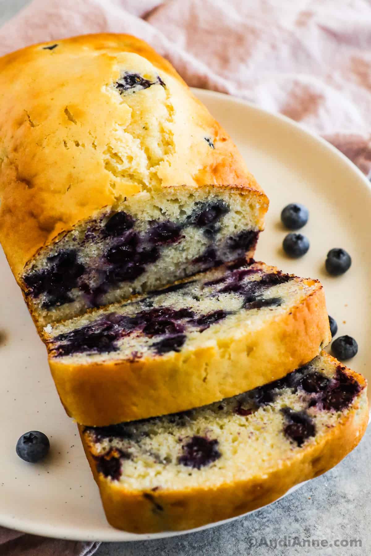 Sliced baked blueberry loaf on a plate.