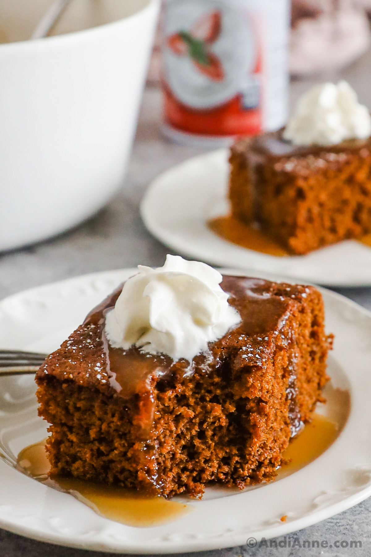 Slices of gingerbread cake topped with caramel sauce and whipped cream.