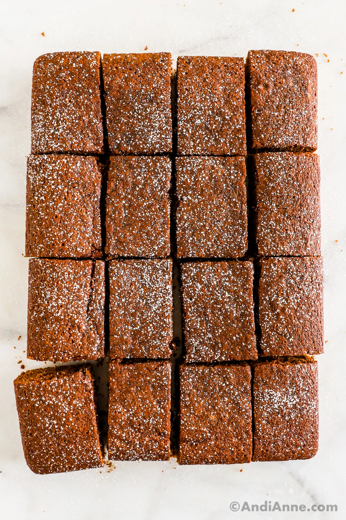 Slices of gingerbread cake lightly dusted with powdered sugar.