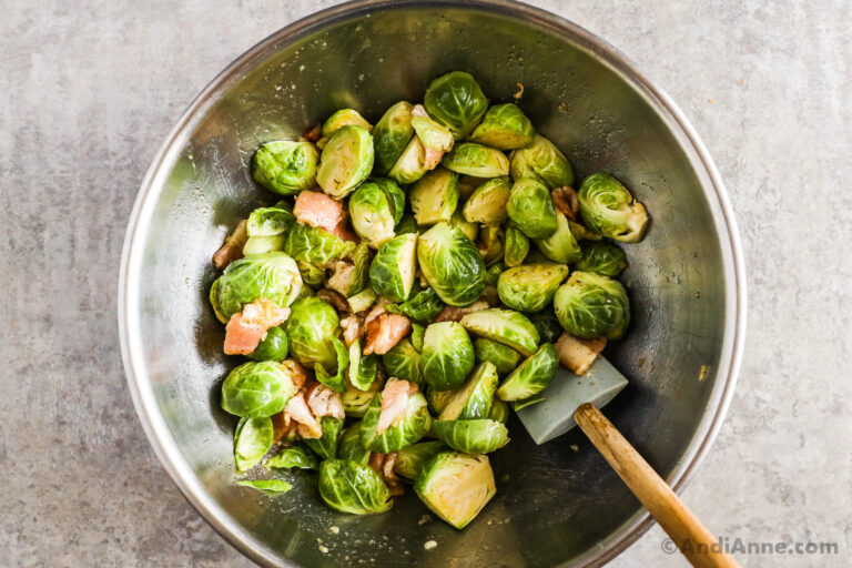 A bowl with brussels sprouts and chopped raw bacon.
