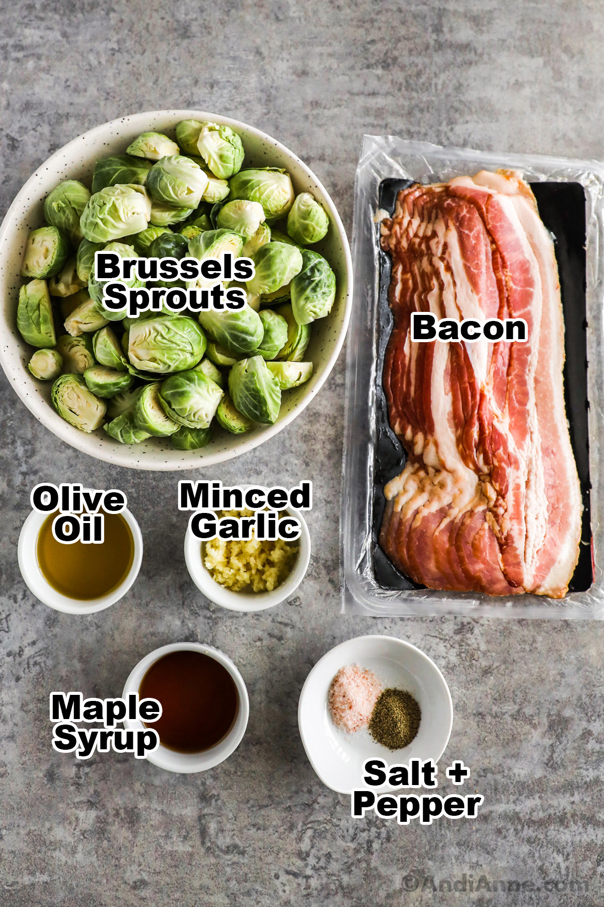Recipe ingredients in bowls including bowls of brussels sprouts, olive oil, minced garlic, maple syrup, salt and pepper and raw bacon slices.