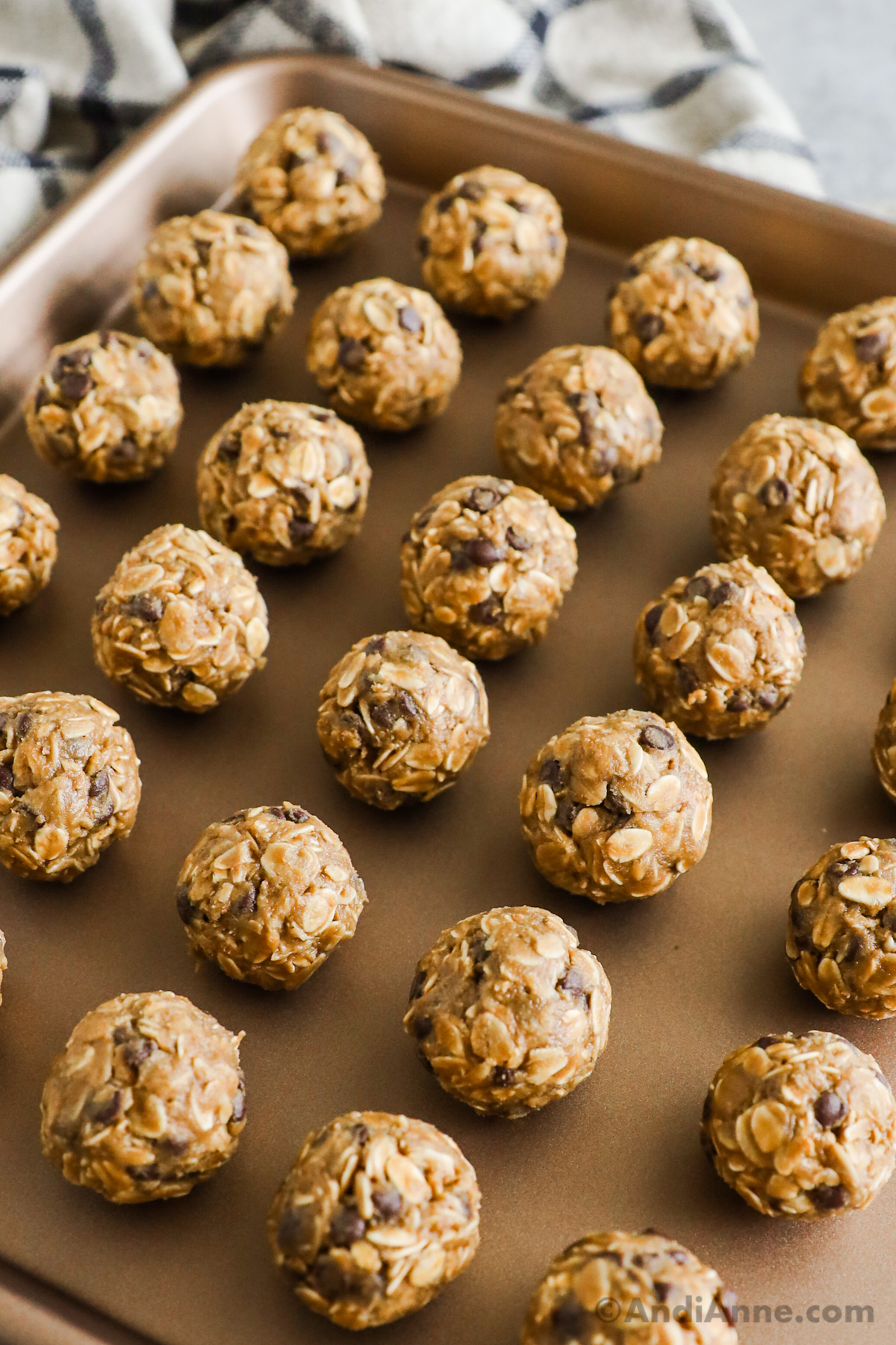 Close up of peanut butter oat balls with chocolate chips, stacked on a plate.