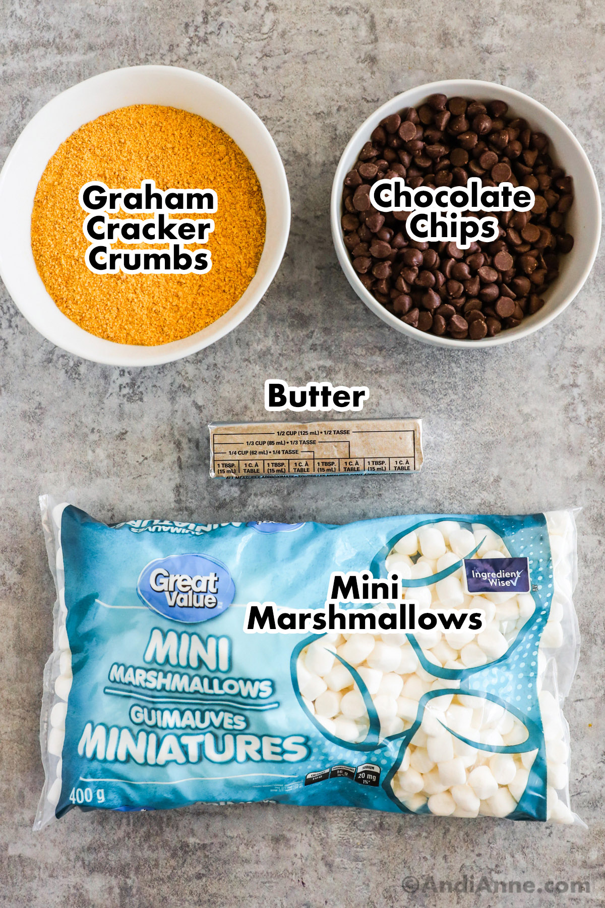 overhead view of ingredients which include: graham cracker crumbs, chocolate chips, butter and a bag of mini marshmallows.