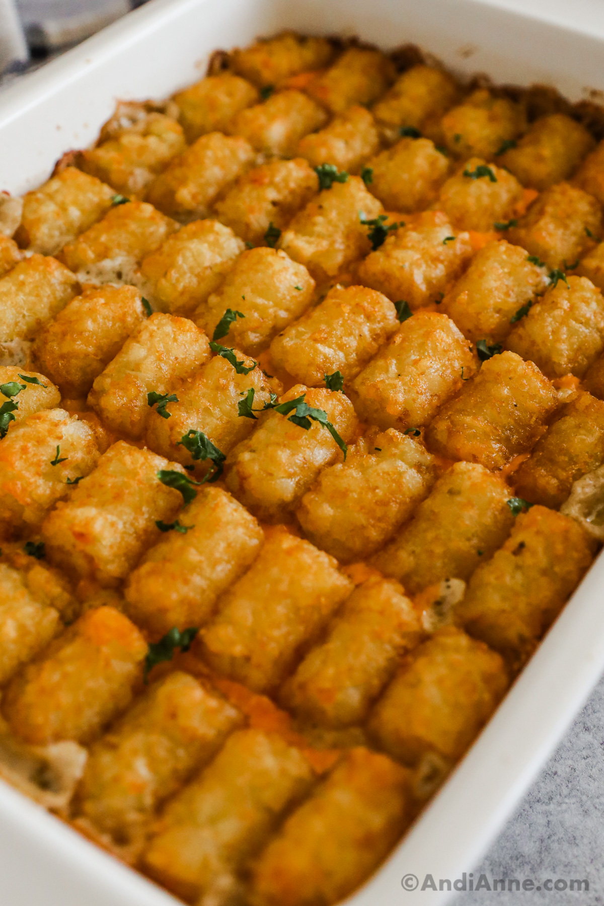 Closeup view of baked casserole, crispy tater tots and cheese.