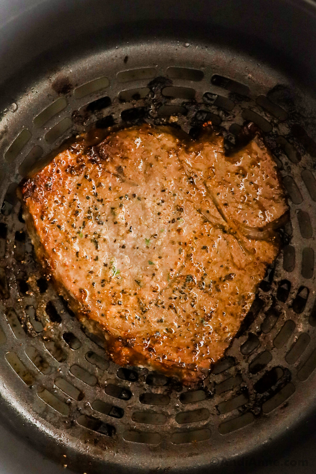 Close up of a cooked steak in an air fryer.