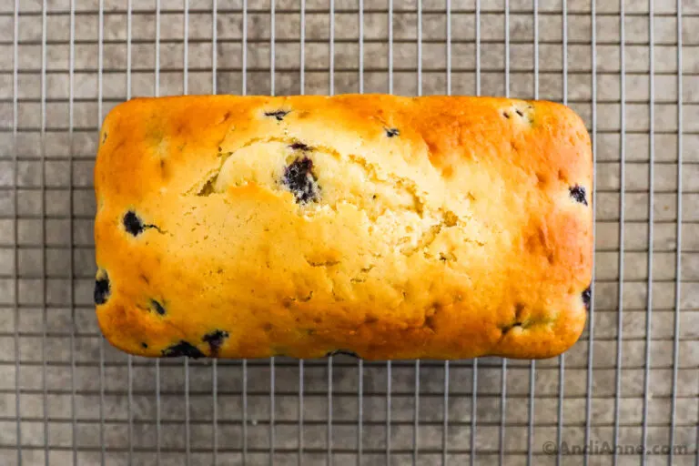Baked blueberry loaf pan on a rack.