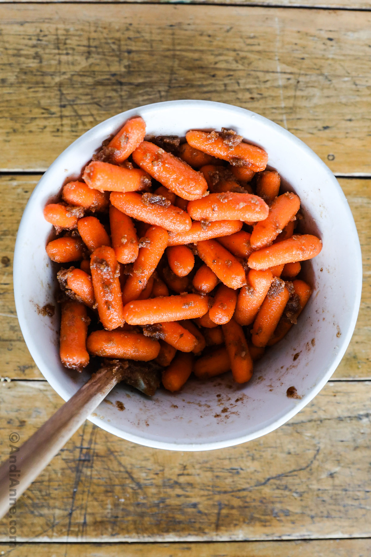 A bowl with carrots and brown sugar butter mixture together, 