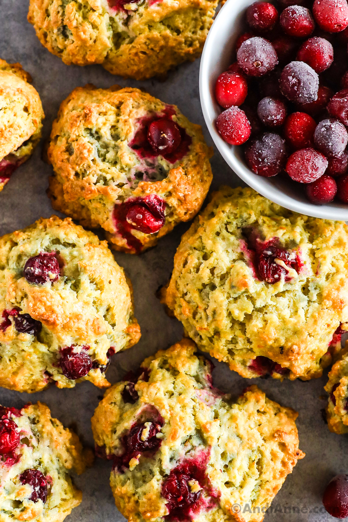 Close up of cranberry scones and a bowl of frozen cranberries. 