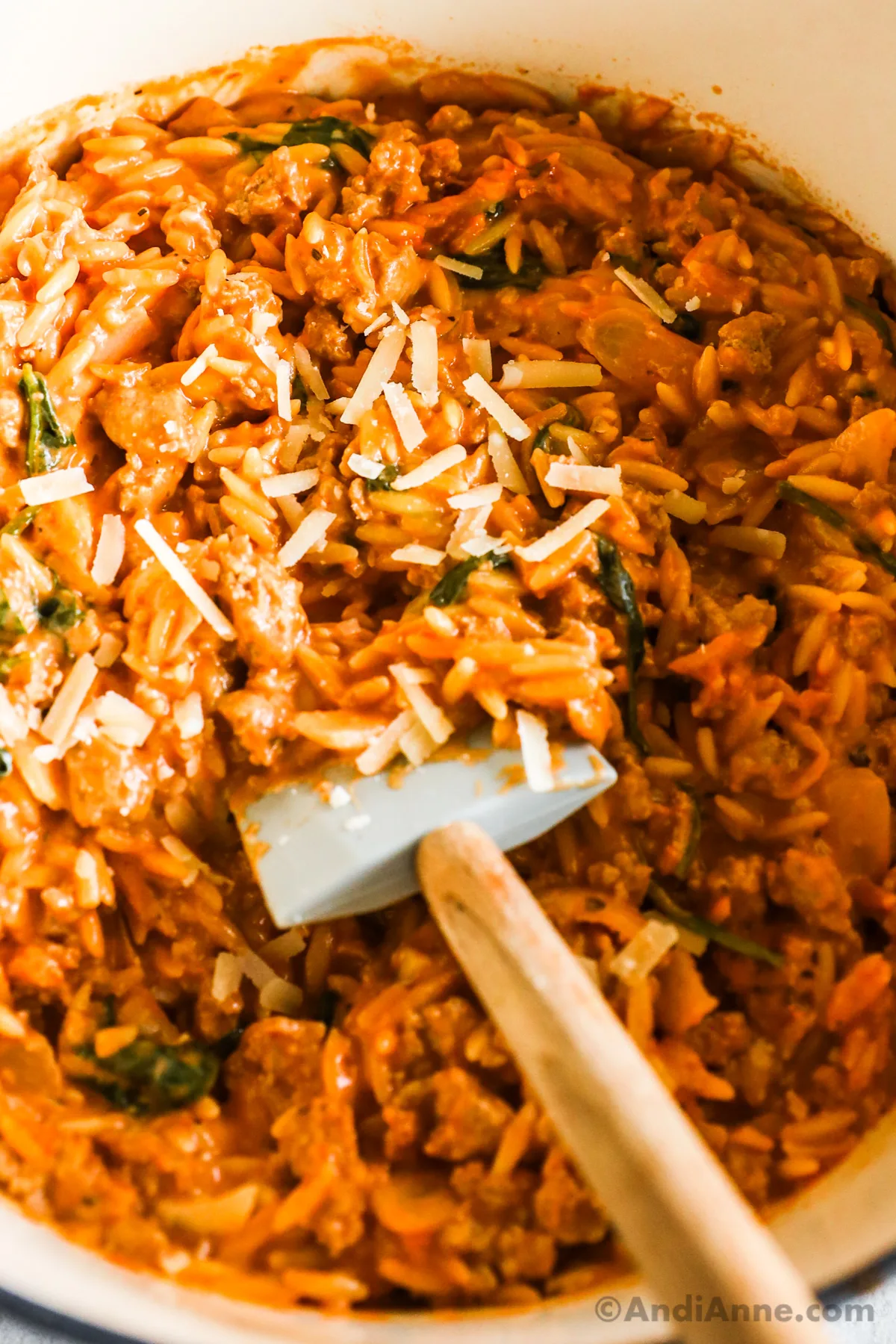 Close up of ground turkey orzo in a tomato sauce, sprinkled with shredded parmesan cheese.