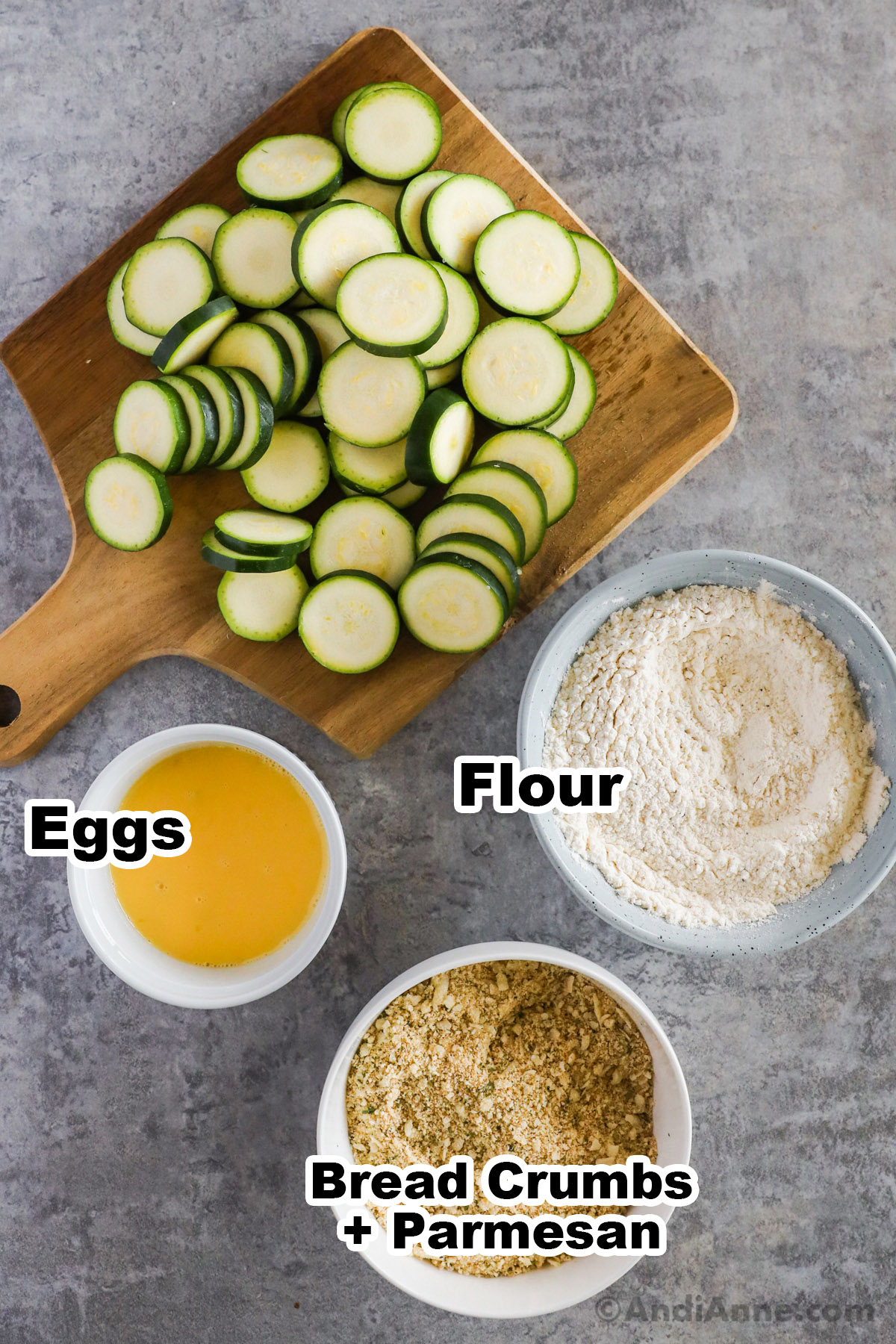 Slice zucchini and three bowls, one with beaten eggs, one with flour, one with bread crumbs.