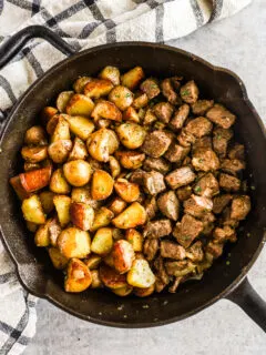 Cooked potatoes and steak bites in a skillet