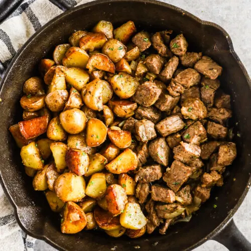 Cooked potatoes and steak bites in a skillet