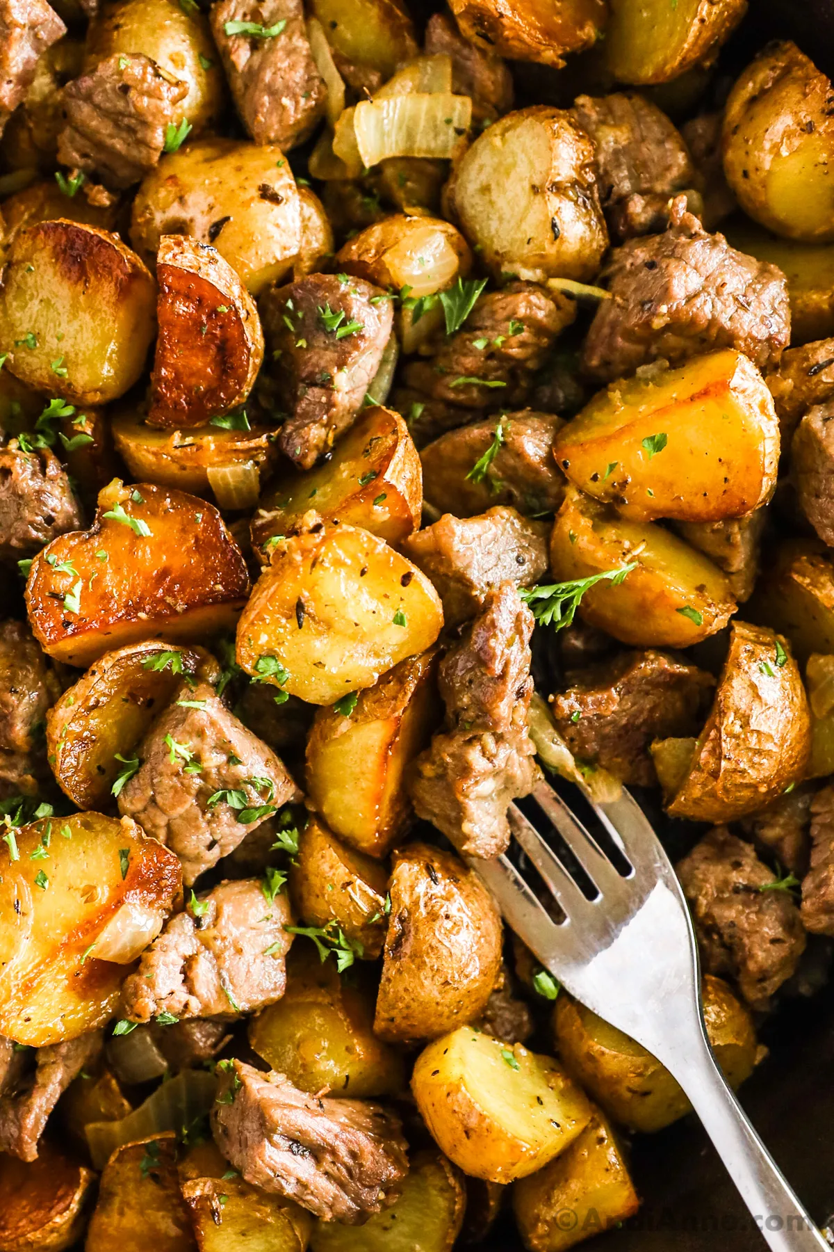 Close up of cooked mini potatoes and steak bites with a fork.