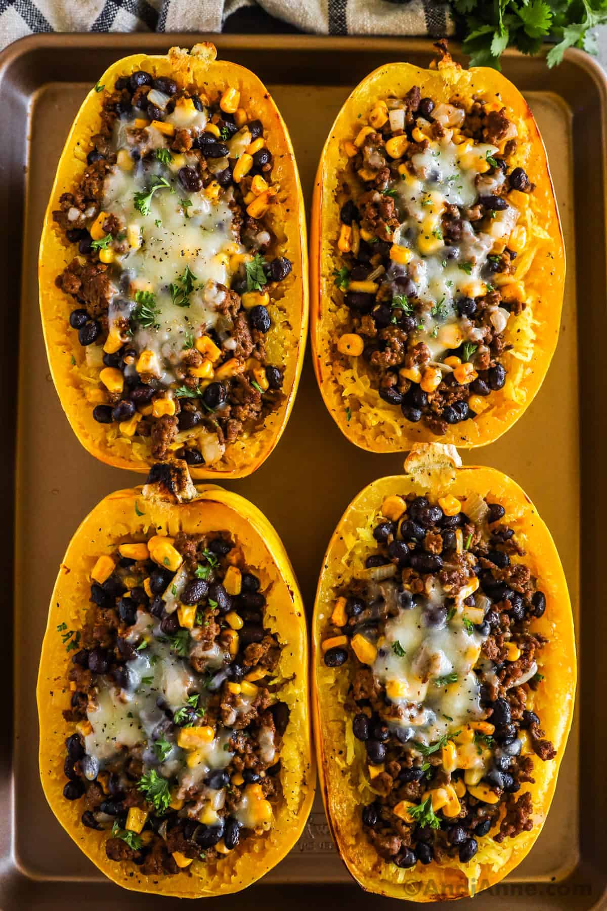 Taco stuffed spaghetti squash on baking sheet.