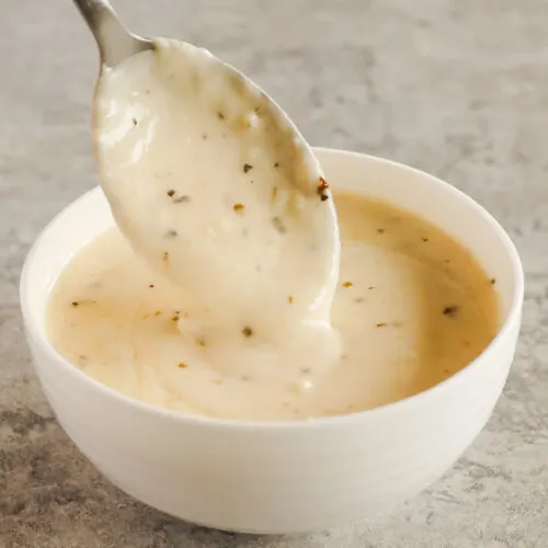 bowl with spoon scooping garlic parmesan sauce