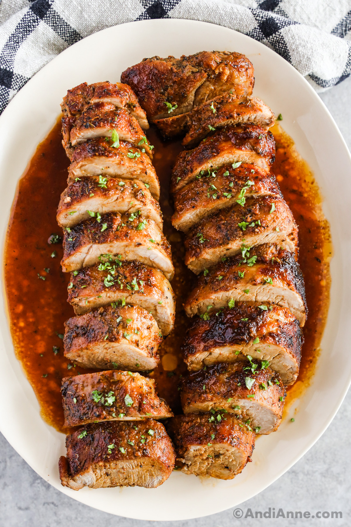 Plate with baked sliced pork tenderloin with juices.