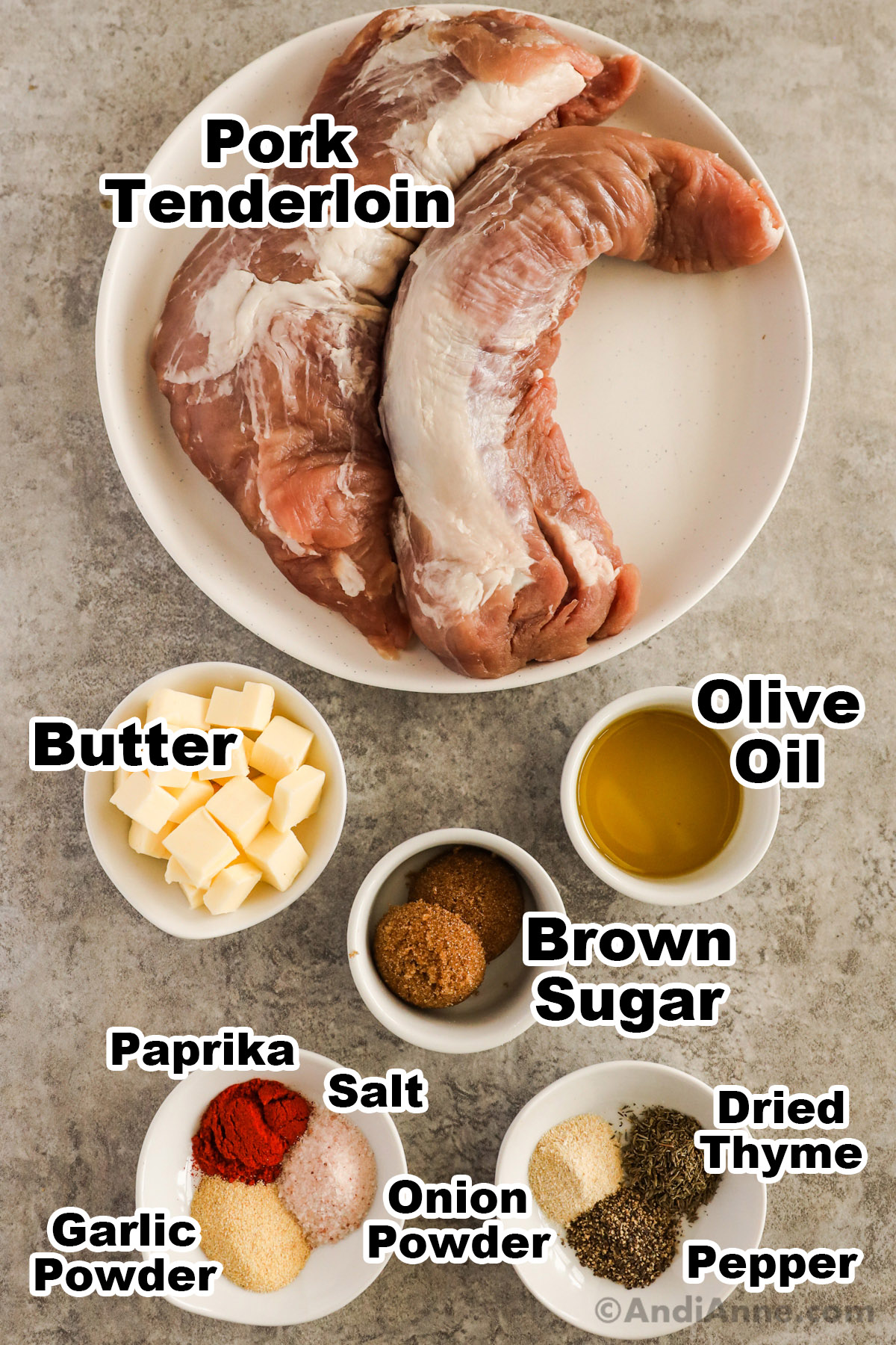 Recipe ingredinets including two raw pork tenderloins, bowls of olive oil, brown sugar, butter, and spices.