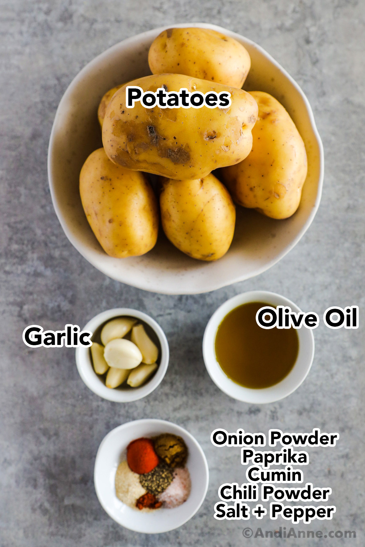 Bowls of potatoes, garlic, olive oil and spices.