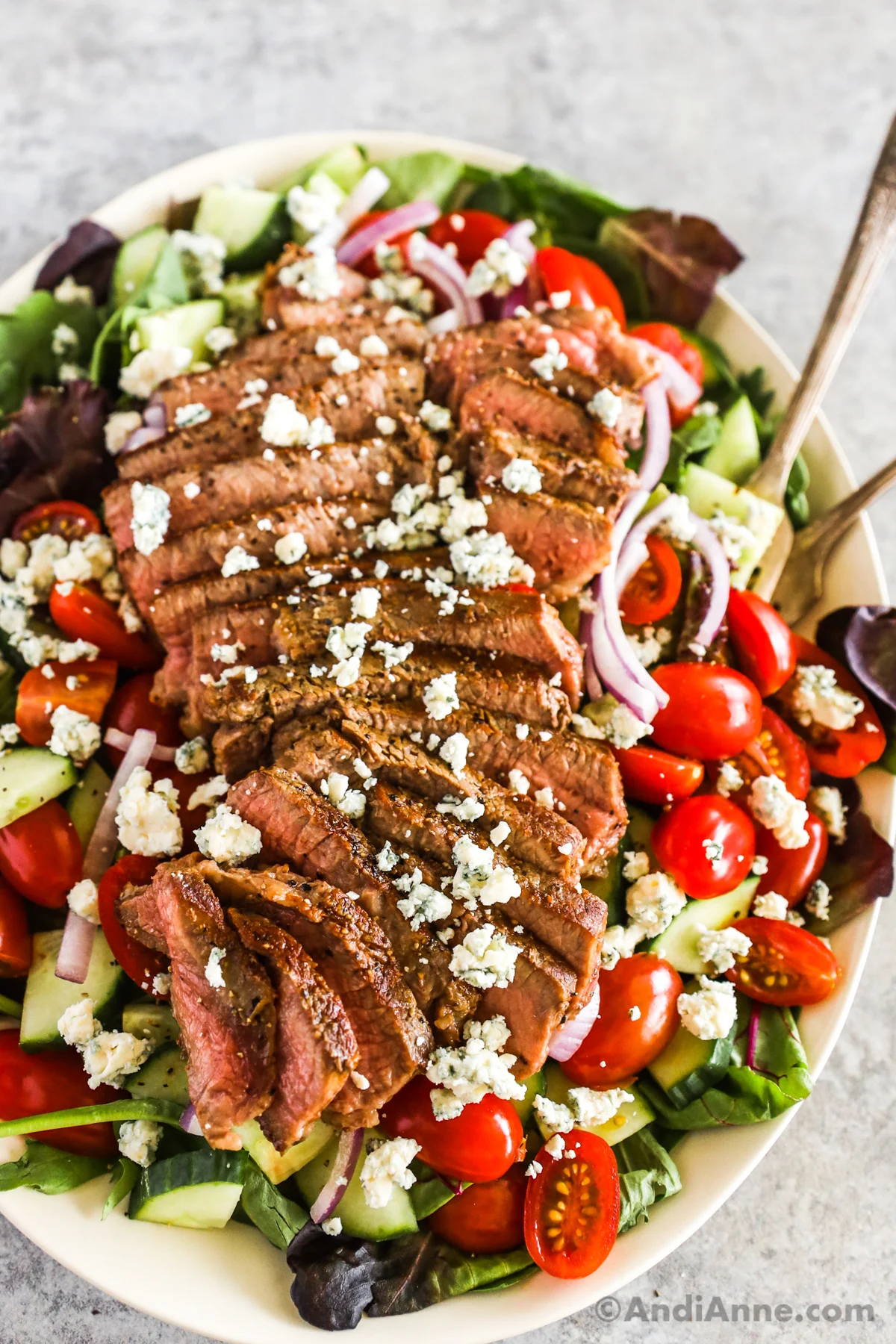 Steak salad recipe with crumbled feta on top of chopped vegetable salad.