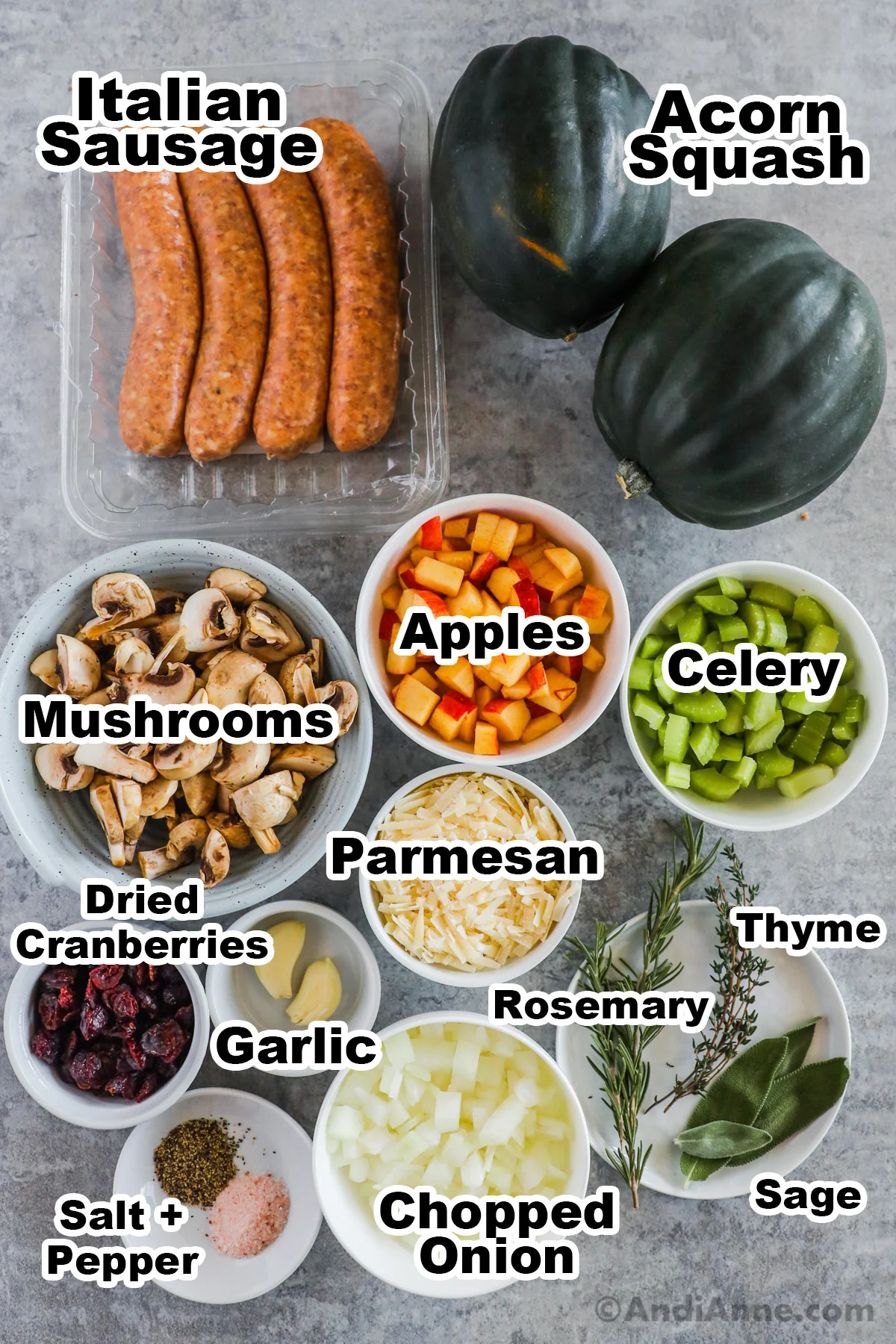 Recipe ingredients in bowls including sausage, acorn squash, chopped apples, mushrooms, celery, parmesan, onion, dried cranberry and fresh spices.