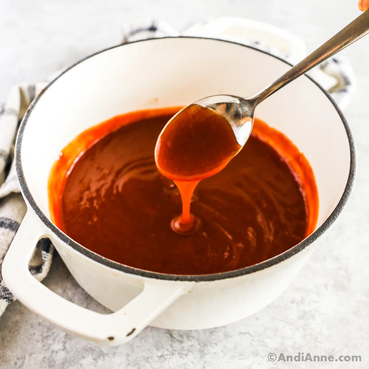 A pot of sweet and sour sauce with a spoon.