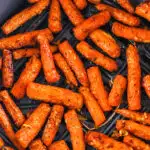 Air fryer basket with cooked chopped carrots inside